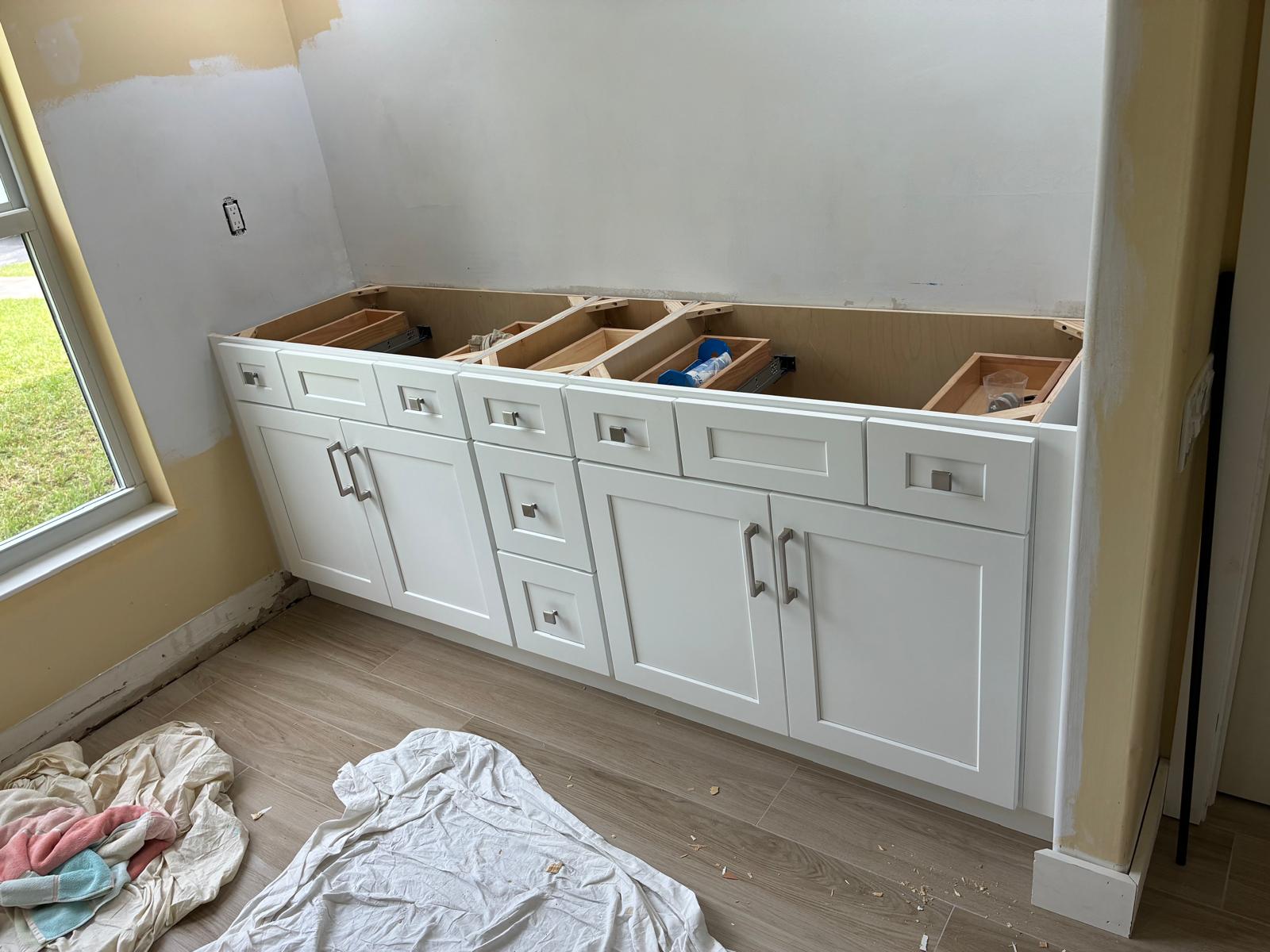 Long white shaker vanity cabinets installed during bathroom remodel