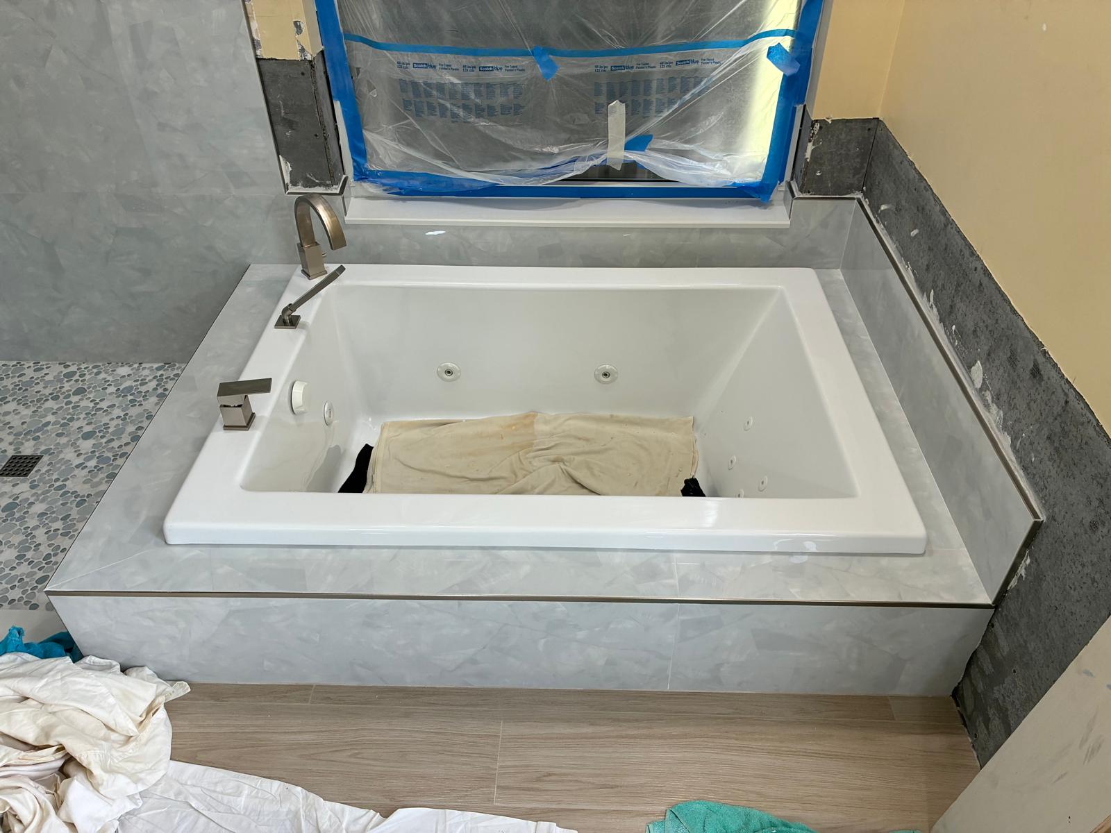 Jetted soaking tub with tiled surround and brushed nickel faucet