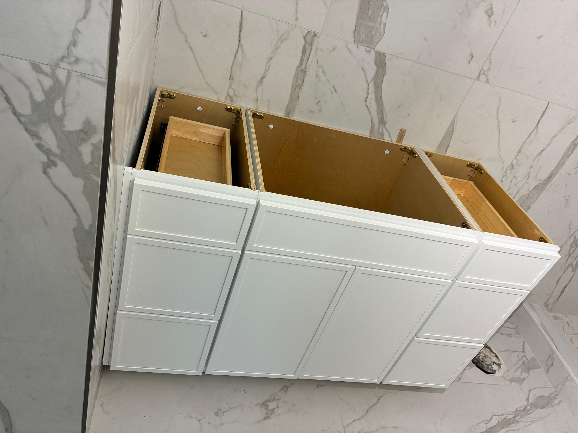 White bathroom vanity cabinet with marble tile walls