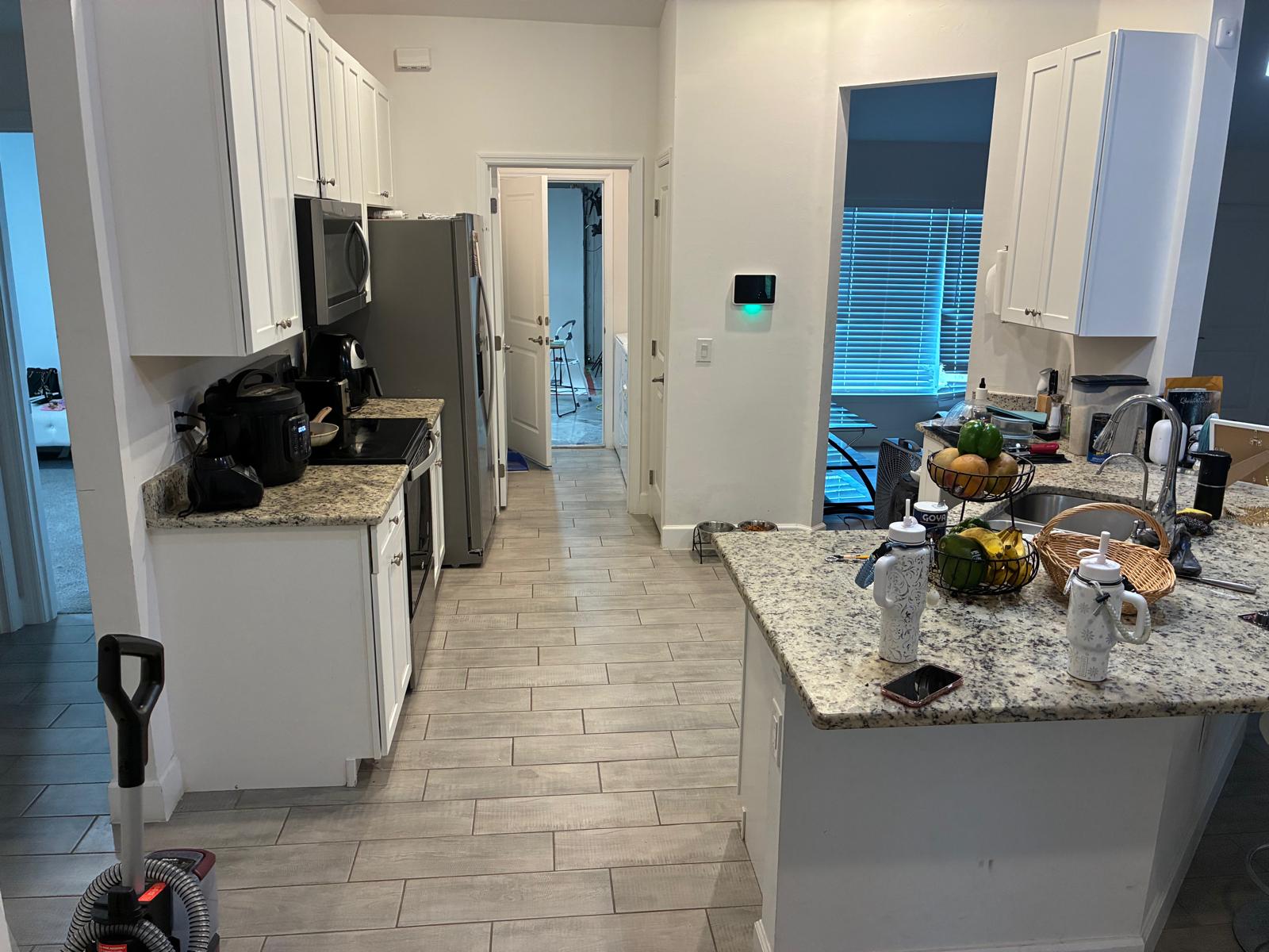 Galley kitchen before remodel with dated granite countertops in Naples FL