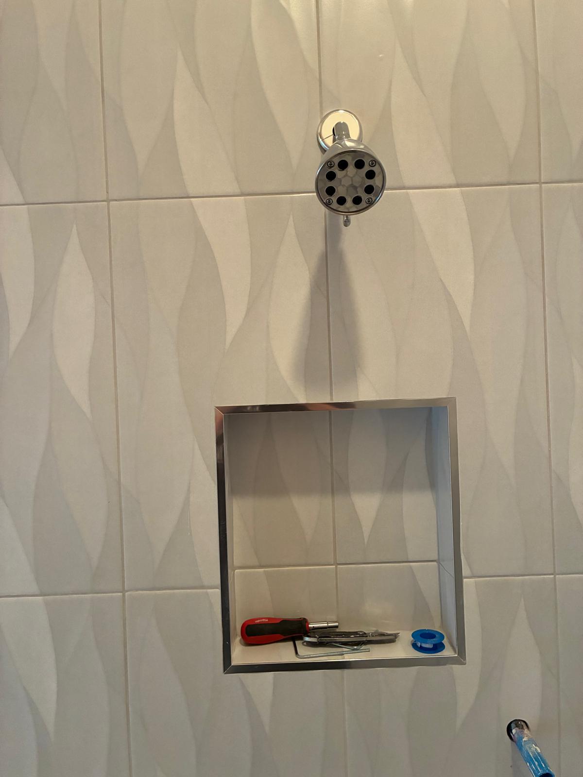 Wave-textured shower tile with stainless steel niche in Naples FL